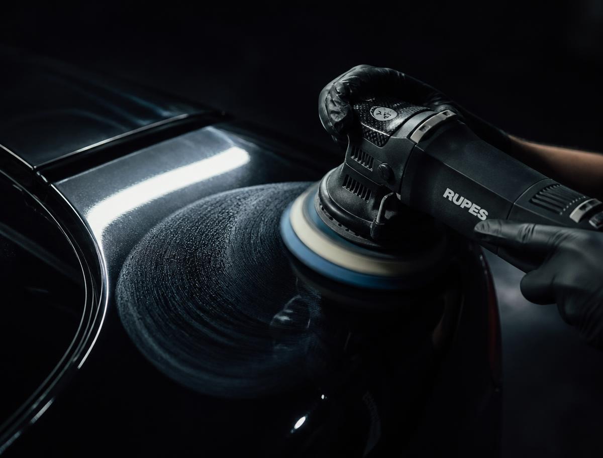 Dual-action polisher correcting swirl marks on glossy black paint